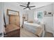 Charming bedroom featuring a ceiling fan, wood floors, and natural light from the window at 2216 Umbrella Tree Dr, Edgewater, FL 32141