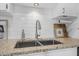 Granite countertop with a double bowl sink and subway tile backsplash in the modern kitchen at 2216 Umbrella Tree Dr, Edgewater, FL 32141