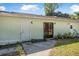 View of the rear of the home with multiple doors and yard with new grass at 2249 Swoope Dr, New Smyrna Beach, FL 32168