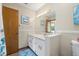 Bathroom featuring a toilet, vanity and mirror with white cabinets at 2249 Swoope Dr, New Smyrna Beach, FL 32168
