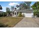 Classic home with attached garage, neat front lawn, brick accents, and a comfortable outdoor seating area at 2249 Swoope Dr, New Smyrna Beach, FL 32168