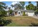 Single-story home boasts a tidy front lawn, mature trees, and attached garage at 2249 Swoope Dr, New Smyrna Beach, FL 32168