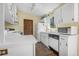 Cozy kitchen with white cabinets and appliances, and view from window at 2249 Swoope Dr, New Smyrna Beach, FL 32168