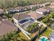 An aerial view showcasing a large house with a screened-in pool and lush landscaping at 2344 Kelbrook Ct, Oviedo, FL 32765