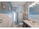 Nautical-themed bathroom with blue walls, wood accents, a vanity, toilet, and walk-in shower at 2344 Kelbrook Ct, Oviedo, FL 32765