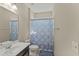 Simple bathroom features a vanity, toilet, and a shower with a patterned blue and white curtain at 2344 Kelbrook Ct, Oviedo, FL 32765