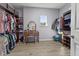 Spacious walk-in closet featuring wood cabinets, a vanity with stool, and natural light from a window at 2344 Kelbrook Ct, Oviedo, FL 32765