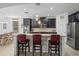 Modern kitchen boasts dark cabinetry, granite countertops, stainless steel appliances, and a breakfast bar with seating at 2344 Kelbrook Ct, Oviedo, FL 32765