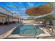 Beautiful pool area with a screened enclosure, sun umbrella, and landscaping for outdoor enjoyment at 2344 Kelbrook Ct, Oviedo, FL 32765