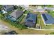Aerial view of a home featuring a solar panel roof, screened-in pool and patio area within a fenced yard at 2393 Oxmoor Dr, Deland, FL 32724