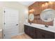Bathroom featuring double sinks with framed round mirrors and wood paneling on the wall at 2393 Oxmoor Dr, Deland, FL 32724
