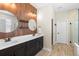 Bathroom featuring a wood panel wall, double sinks, and two mirrors above the sinks at 2393 Oxmoor Dr, Deland, FL 32724