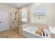 Modern bathroom featuring glass shower, soaking tub, and wood-look tile at 2393 Oxmoor Dr, Deland, FL 32724