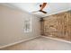 Bedroom with a unique wood accent wall, large window, and neutral carpeting at 2393 Oxmoor Dr, Deland, FL 32724