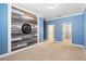 Stylish bedroom featuring a blue accent wall with unique wood paneling and neutral carpeting at 2393 Oxmoor Dr, Deland, FL 32724