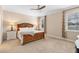 Bright bedroom with a ceiling fan, neutral paint, two windows, and a wooden bed frame at 2393 Oxmoor Dr, Deland, FL 32724