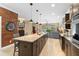 Open kitchen with large island, granite countertops, pendant lights, and wood accent wall at 2393 Oxmoor Dr, Deland, FL 32724
