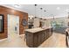 Kitchen island with sink, wood floors, and view to the laundry room and living room at 2393 Oxmoor Dr, Deland, FL 32724
