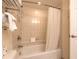 Tiled bathtub and shower with white curtain and mounted towel racks at 2700 N Atlantic Ave # 454, Daytona Beach, FL 32118