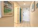 Hallway with tile floors and coastal artwork leading to a bedroom and doorway at 2700 N Atlantic Ave # 454, Daytona Beach, FL 32118