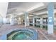 Indoor pool area with a hot tub and access to the pool, featuring tile flooring and bright lighting at 2700 N Atlantic Ave # 454, Daytona Beach, FL 32118