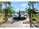 Circular fountain surrounded by lush greenery and palm trees at the property entrance at 2801 S Ridgewood Ave # 1214, South Daytona, FL 32119