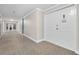 Hallway with neutral carpet leads to unit door with white trim and overhead lighting at 2801 S Ridgewood Ave # 1214, South Daytona, FL 32119