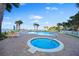 Community pool and hot tub area with lounge chairs, umbrellas, and lush tropical landscaping at 2801 S Ridgewood Ave # 1214, South Daytona, FL 32119