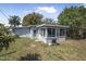 Charming home featuring a backyard, mature landscaping, and a cozy sunroom extension with bright windows at 2821 Oak Lea Dr, South Daytona, FL 32119