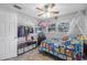 Bright bedroom with playful decor, ceiling fan, and a clothing rack at 2821 Oak Lea Dr, South Daytona, FL 32119