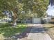 Single-story home with a driveway and a well-manicured front lawn at 2821 Oak Lea Dr, South Daytona, FL 32119