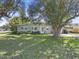 Single-story home featuring a lush green lawn and mature trees at 2821 Oak Lea Dr, South Daytona, FL 32119