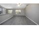 Bright living room with hardwood floors, ceiling fan, and natural light from the two windows at 2841 Idleweise Dr, Deltona, FL 32738