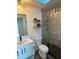 Updated bathroom with glass-enclosed shower, modern vanity and shelves, and pebble flooring at 2929 Carriage Dr, South Daytona, FL 32119