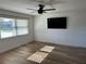 Bright bedroom with wood-look floors, ceiling fan and a mounted TV at 2929 Carriage Dr, South Daytona, FL 32119
