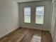 Bright bedroom features wood-look floors and natural light from two windows with blinds at 2929 Carriage Dr, South Daytona, FL 32119