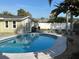 A serene swimming pool surrounded by a lush garden and comfortable lounge chairs at 2929 Carriage Dr, South Daytona, FL 32119