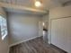 Bright bedroom featuring wood-look flooring, white trim, closet, and view to the living area at 305 Elsie Ave, Daytona Beach, FL 32117