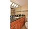 Bathroom with a vanity featuring a black granite countertop and wood cabinets at 3051 S Atlantic Ave # 2206, Daytona Beach, FL 32118