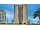Oceanfront high-rise condo building with palm trees and a blue sky backdrop at 3051 S Atlantic Ave # 2206, Daytona Beach, FL 32118
