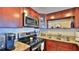 Close up on cherry cabinets and stainless appliances in this modern kitchen at 3051 S Atlantic Ave # 2206, Daytona Beach, FL 32118