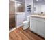 Bathroom featuring a glass shower, wood-look flooring, and a vanity with white cabinets at 3102 Cordgrass Ct, The Villages, FL 32163