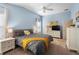 Comfortable bedroom features blue walls, a ceiling fan, and a yellow-accented gray bedspread at 3102 Cordgrass Ct, The Villages, FL 32163