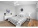 Bright bedroom featuring a ceiling fan, a floral-patterned bedspread, and simple, clean decor at 3102 Cordgrass Ct, The Villages, FL 32163