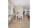 Bright dining room with wood floors and a stylish chandelier overlooking the kitchen at 3102 Cordgrass Ct, The Villages, FL 32163