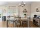 A stylish dining room with wood floors, modern lighting, and tasteful decorations creating a cozy and inviting space at 3102 Cordgrass Ct, The Villages, FL 32163