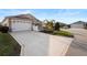 Home exterior with a manicured lawn, long driveway, and an attached two-car garage at 3102 Cordgrass Ct, The Villages, FL 32163