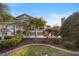 Landscaped front yard with green grass and mature trees, enhancing the curb appeal of the home at 3102 Cordgrass Ct, The Villages, FL 32163