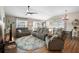 Spacious living room featuring wood flooring, large windows, and comfortable seating arrangements at 3102 Cordgrass Ct, The Villages, FL 32163