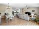 Open-concept living and dining area featuring wood flooring, neutral paint, and modern lighting fixtures at 3102 Cordgrass Ct, The Villages, FL 32163